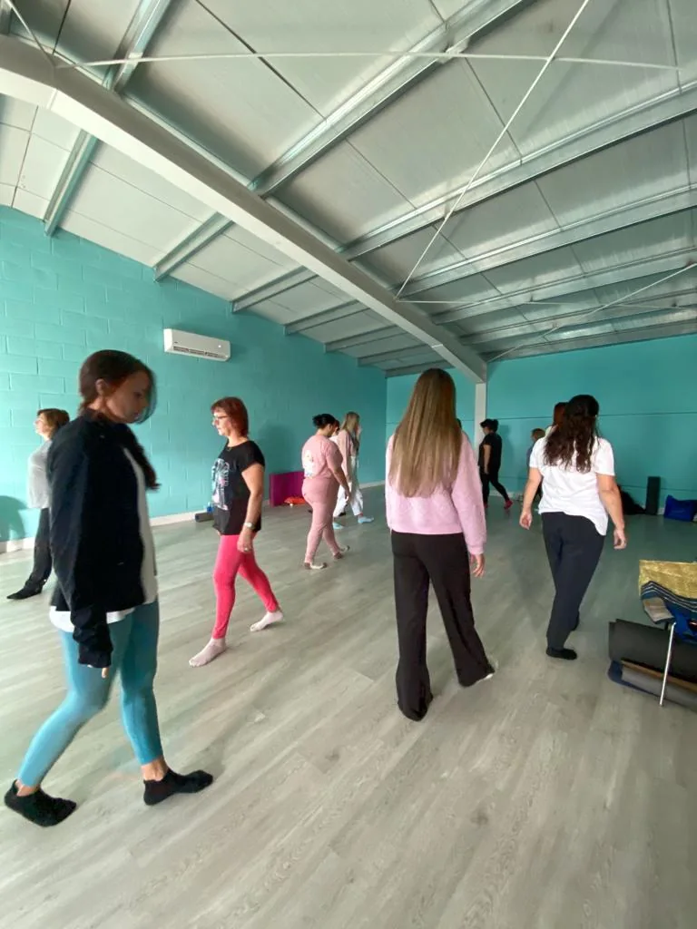 Mujeres caminando por una sala durante una dinámica de grupo en un taller