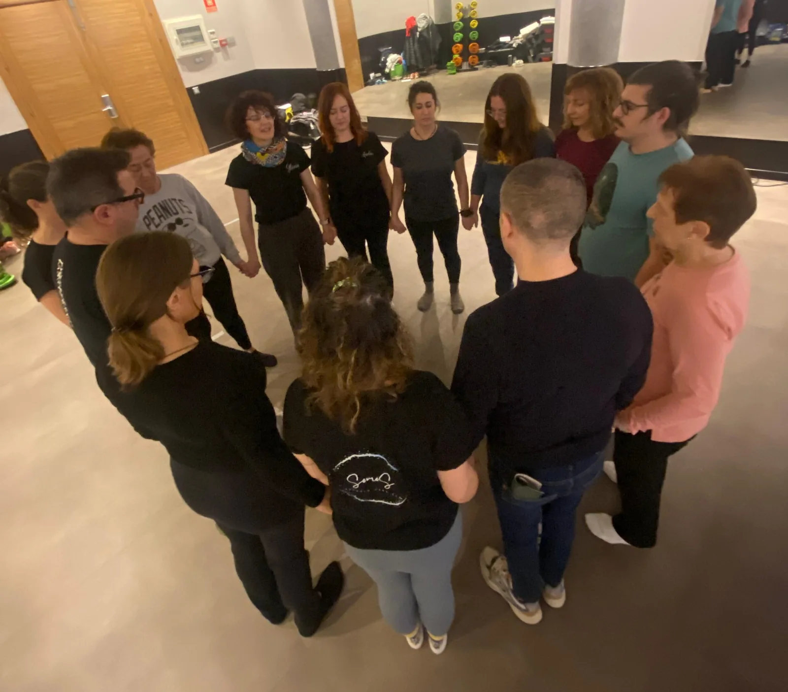 Grupo de personas de pie formando un círculo en un encuentro