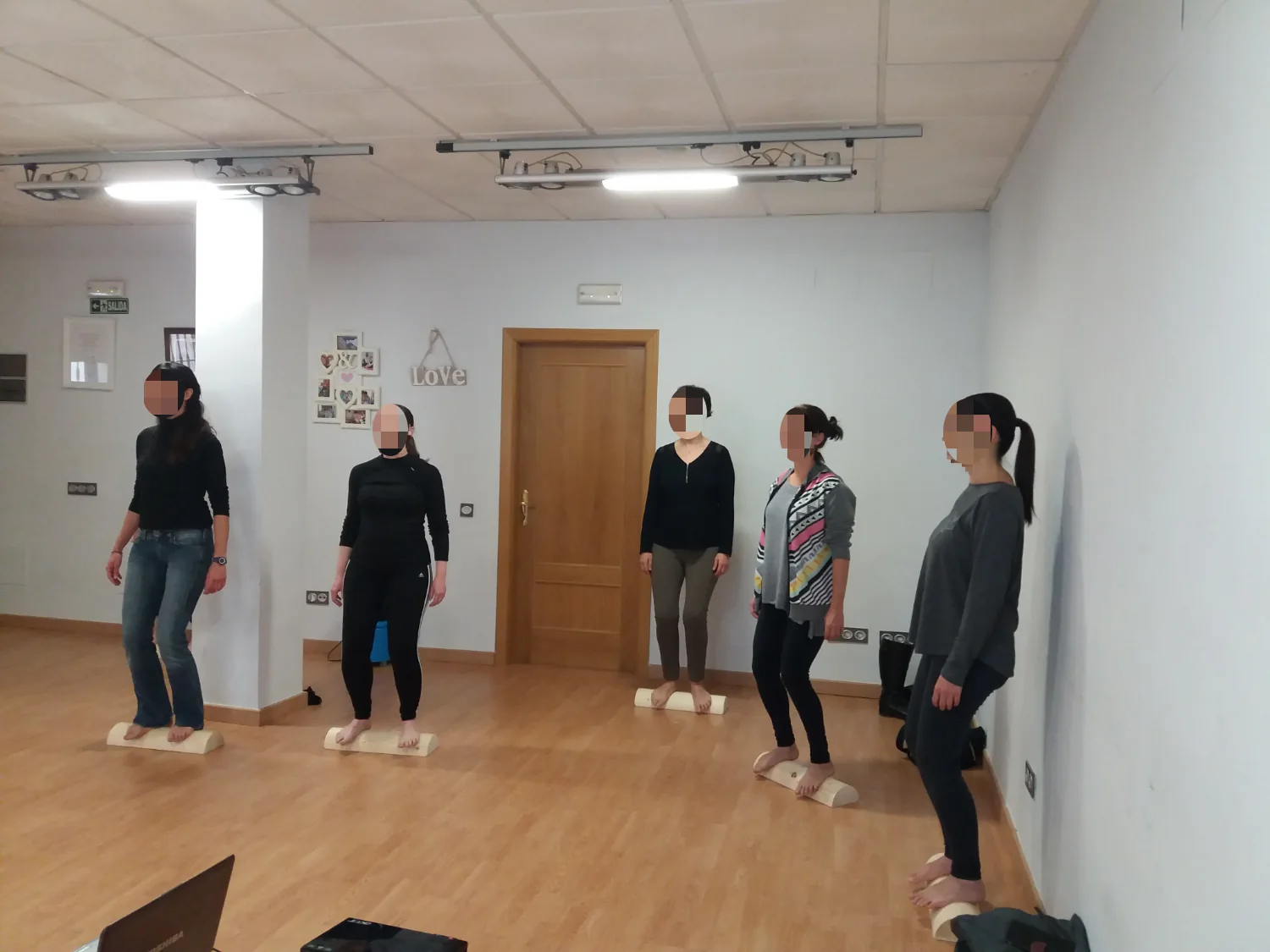 Cinco participantes de pie en fila sobre tacos de madera durante un taller del Método 5P