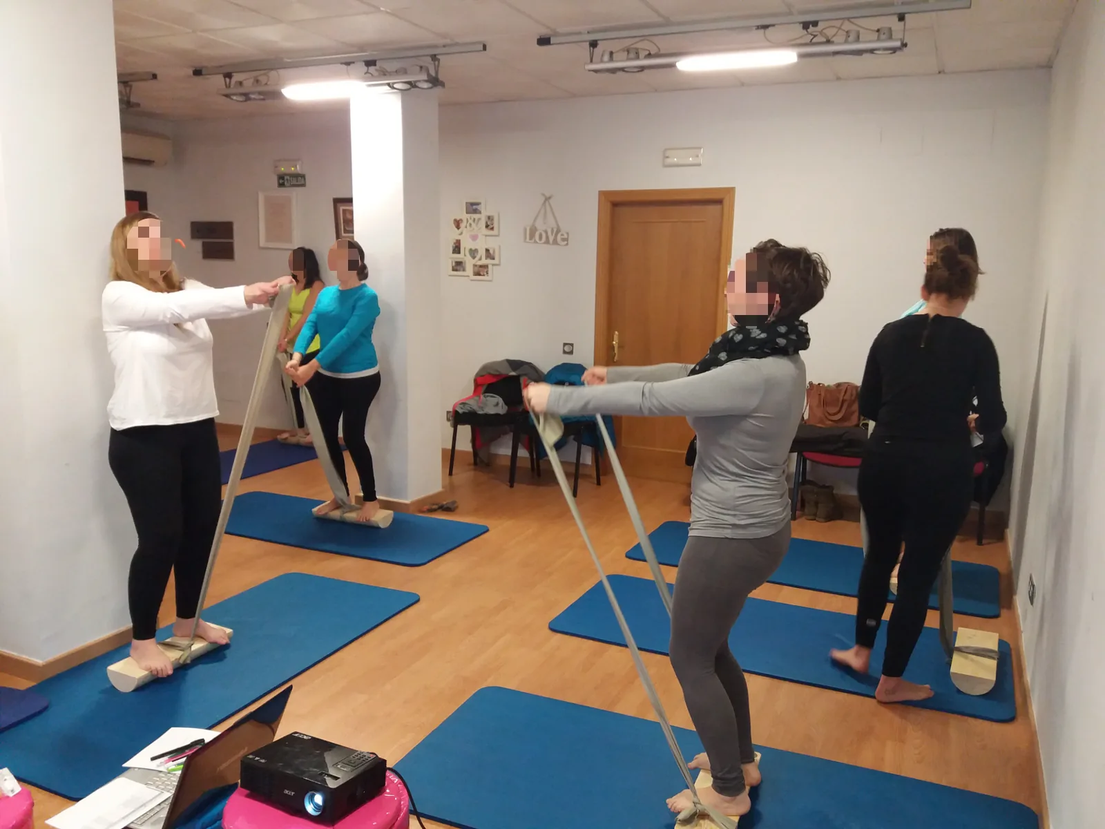 Participantes de un taller del Método 5P trabajan de pie con bandas elásticas sobre colchonetas